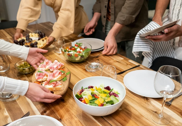 Des amis partageant un repas autour d'une table chargée de plats préparés avec des produits Galbani